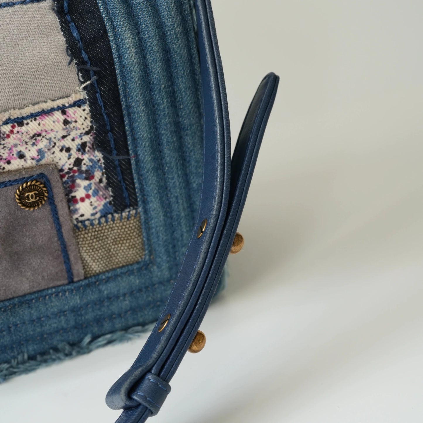 Detail view of aged gold Boy clasp and patchwork denim fabric details