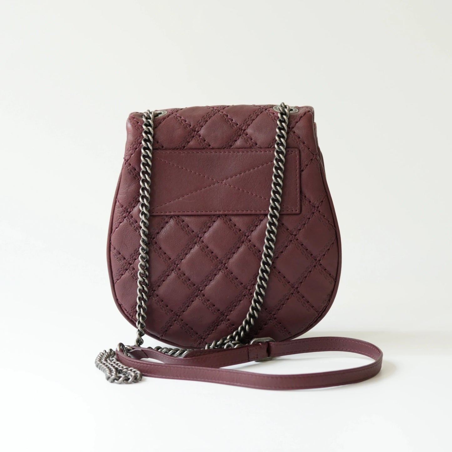 Back view of Chanel burgundy quilted mini flap bag with smooth solid leather rear surface