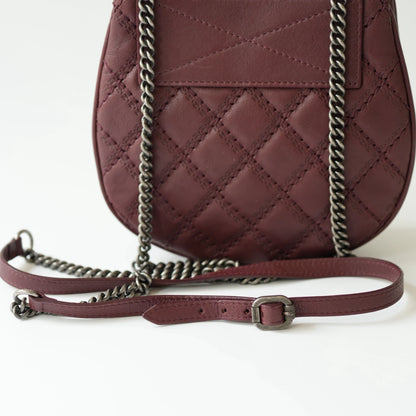 Close-up of engraved CC turnlock and metal tassel detail on quilted leather bag