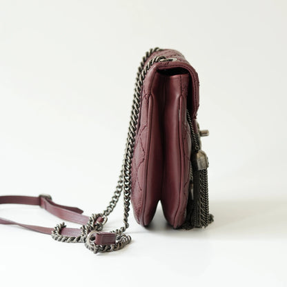 Side view of Chanel tassel mini bag showing slim profile and adjustable leather strap