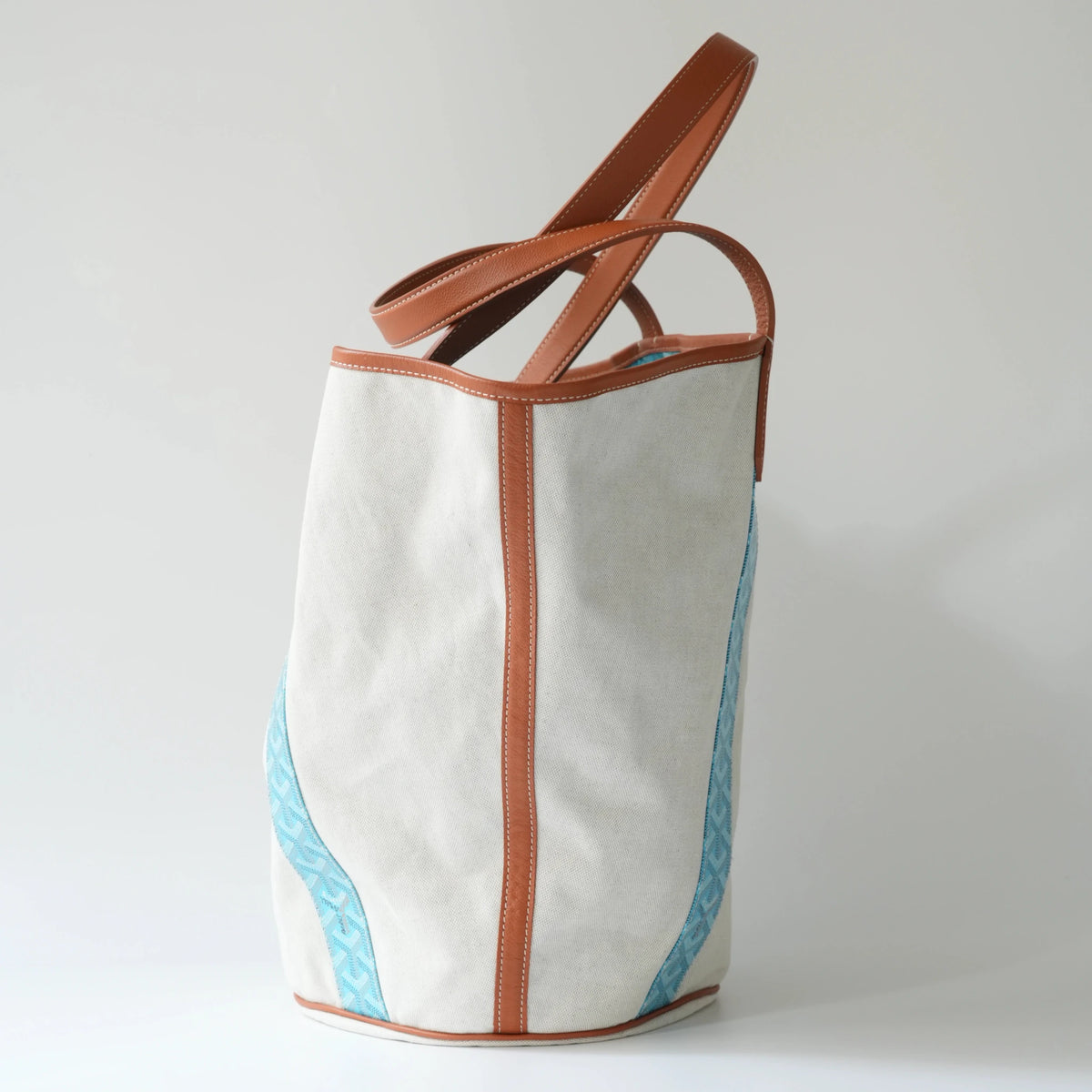 Side view: Side view of Goyard Belharra MM tote, showing bag depth, leather handle structure and tapered silhouette 2