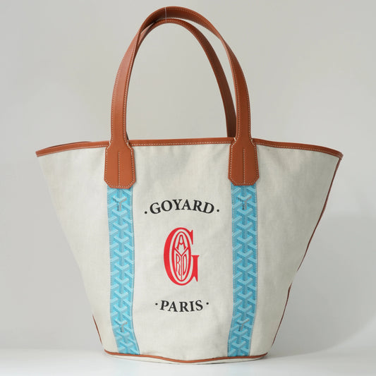 Front view: Front view of Goyard Belharra MM reversible tote, turquoise Goyardine canvas with cognac brown calfskin trim and dual top handles2