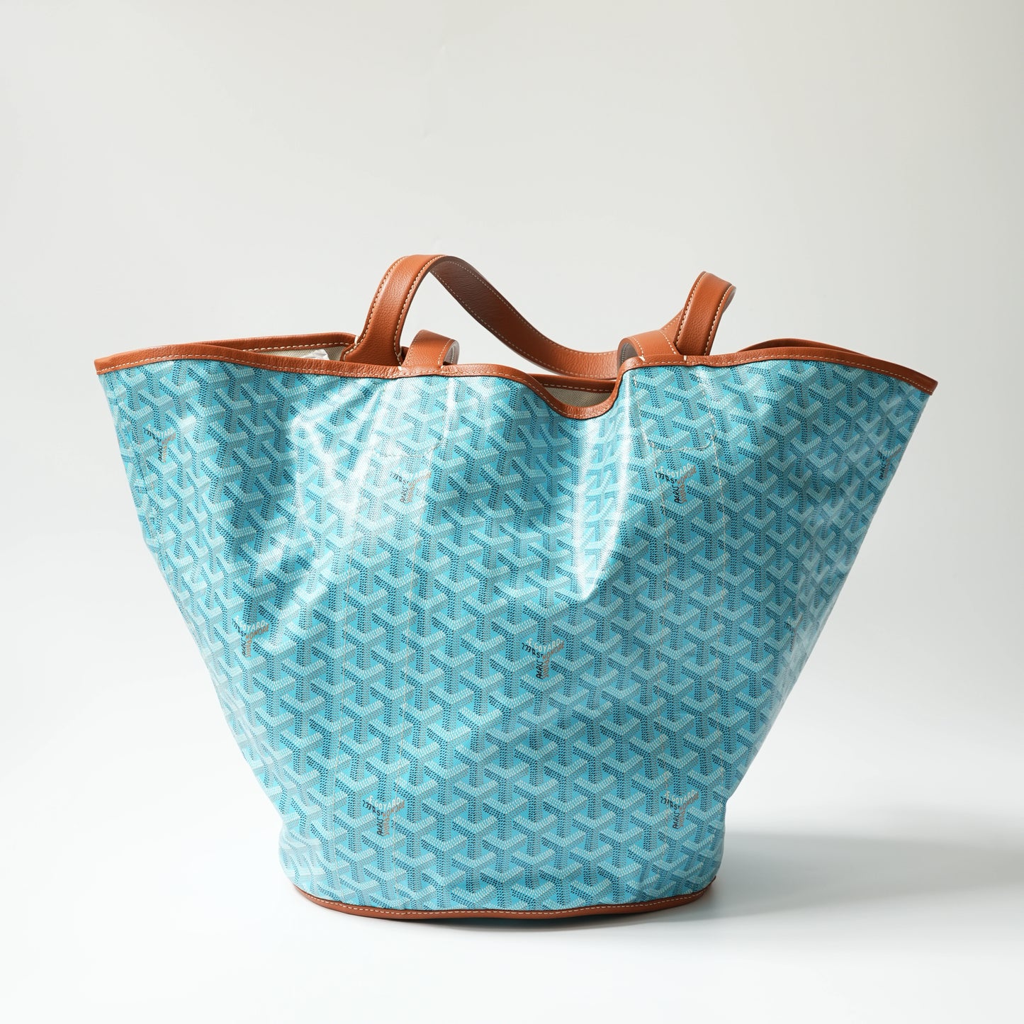 Front view: Front view of Goyard Belharra MM reversible tote, turquoise Goyardine canvas with cognac brown calfskin trim and dual top handles