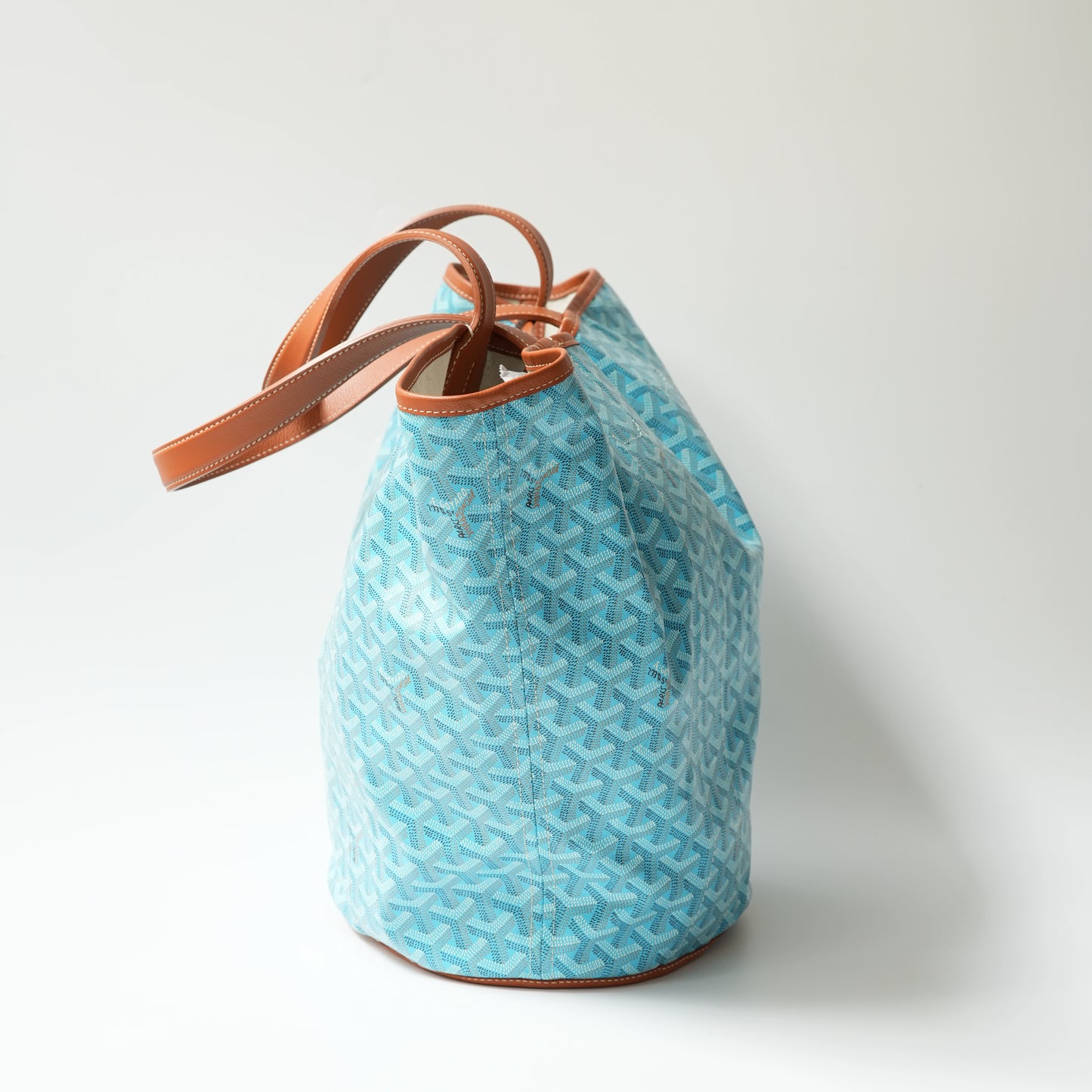 Side view: Side view of Goyard Belharra MM tote, showing bag depth, leather handle structure and tapered silhouette