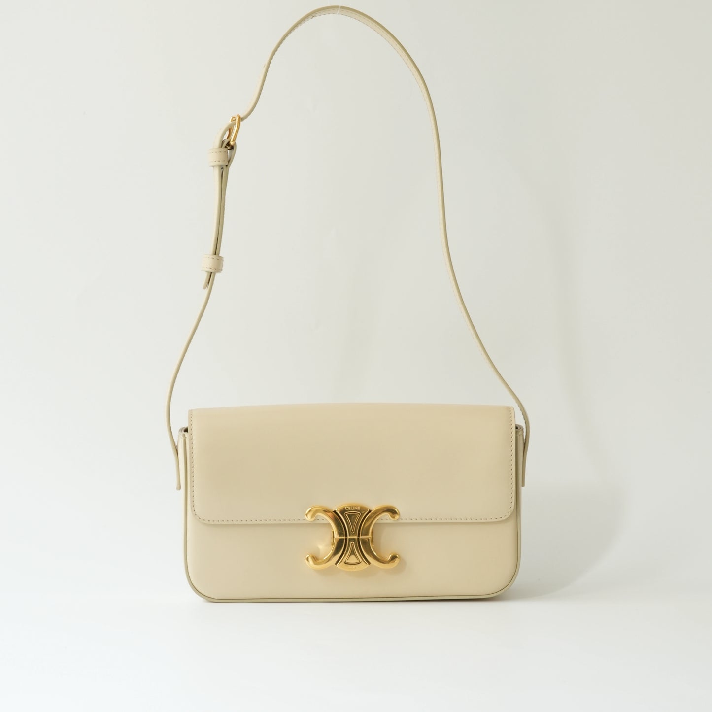 Front view of Celine Triomphe shoulder bag in ivory shiny calfskin with gold Triomphe clasp