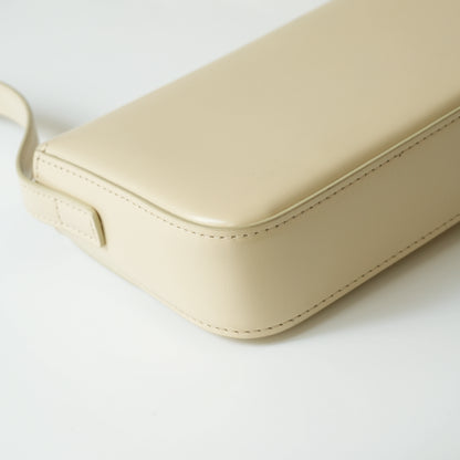 Detail view of gold Triomphe clasp and precise leather stitching