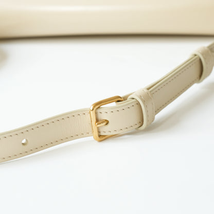 Detail view of gold Triomphe clasp and precise leather stitching