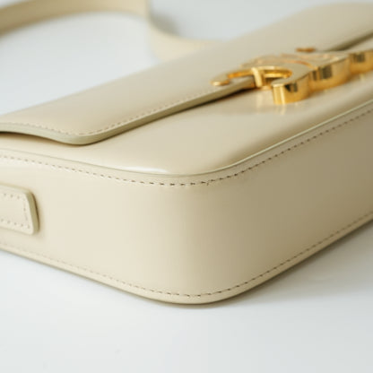 Detail view of gold Triomphe clasp and precise leather stitching