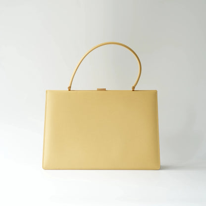 Front view of Celine yellow leather clasp top handle bag with sleek structured minimalist silhouette