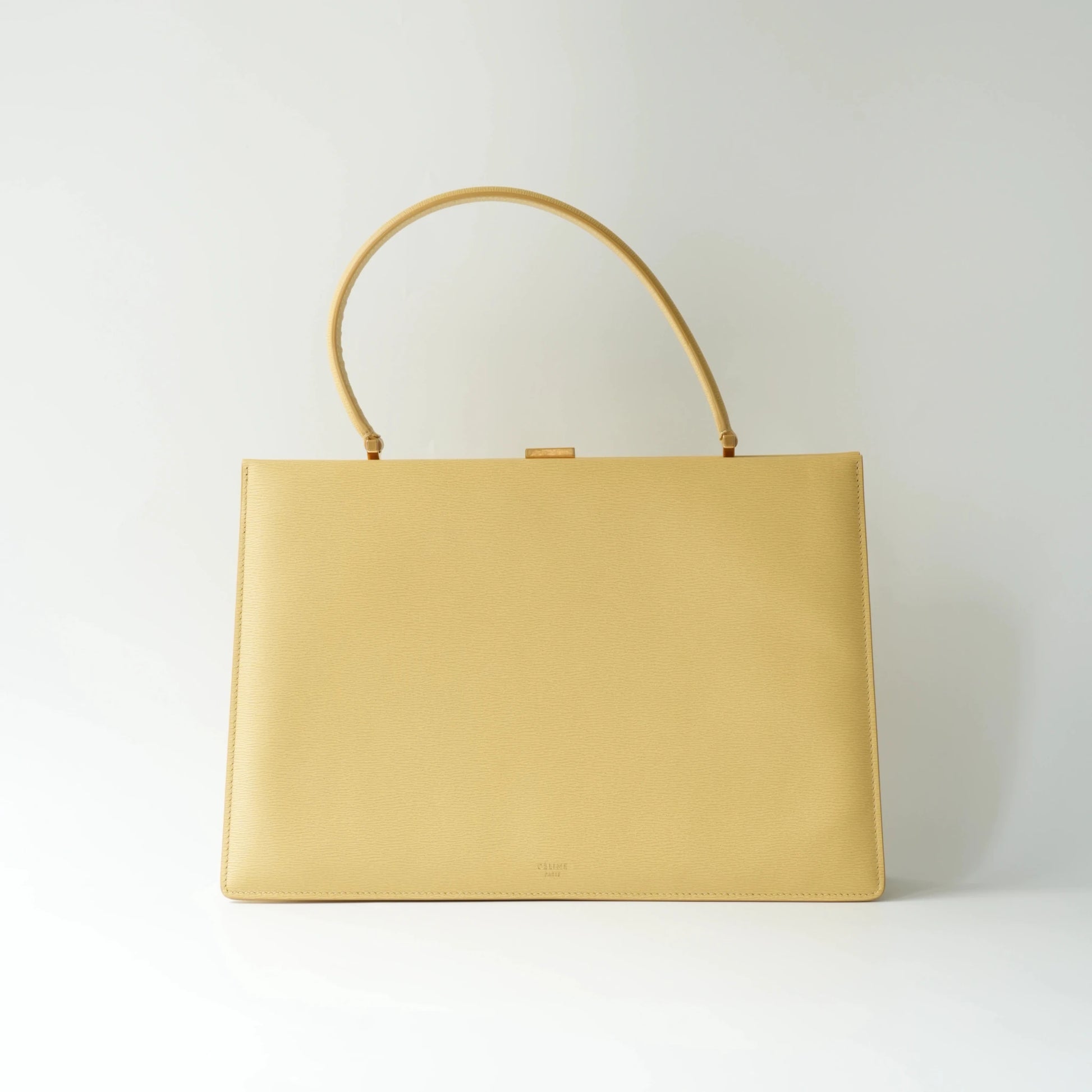 Back view of Celine yellow leather clasp top handle bag with clean grained leather finish