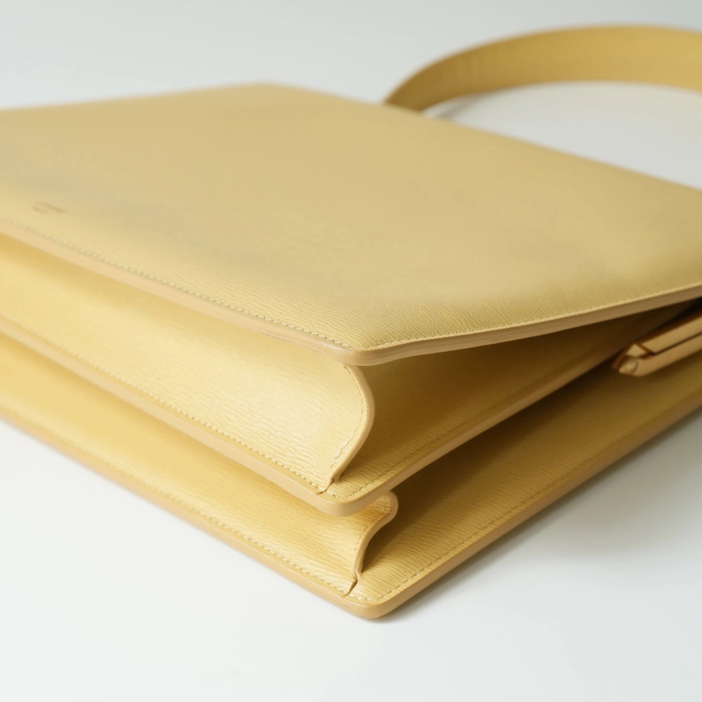 Detail view of Celine clasp bag precision leather stitching and high-shine metal hardware