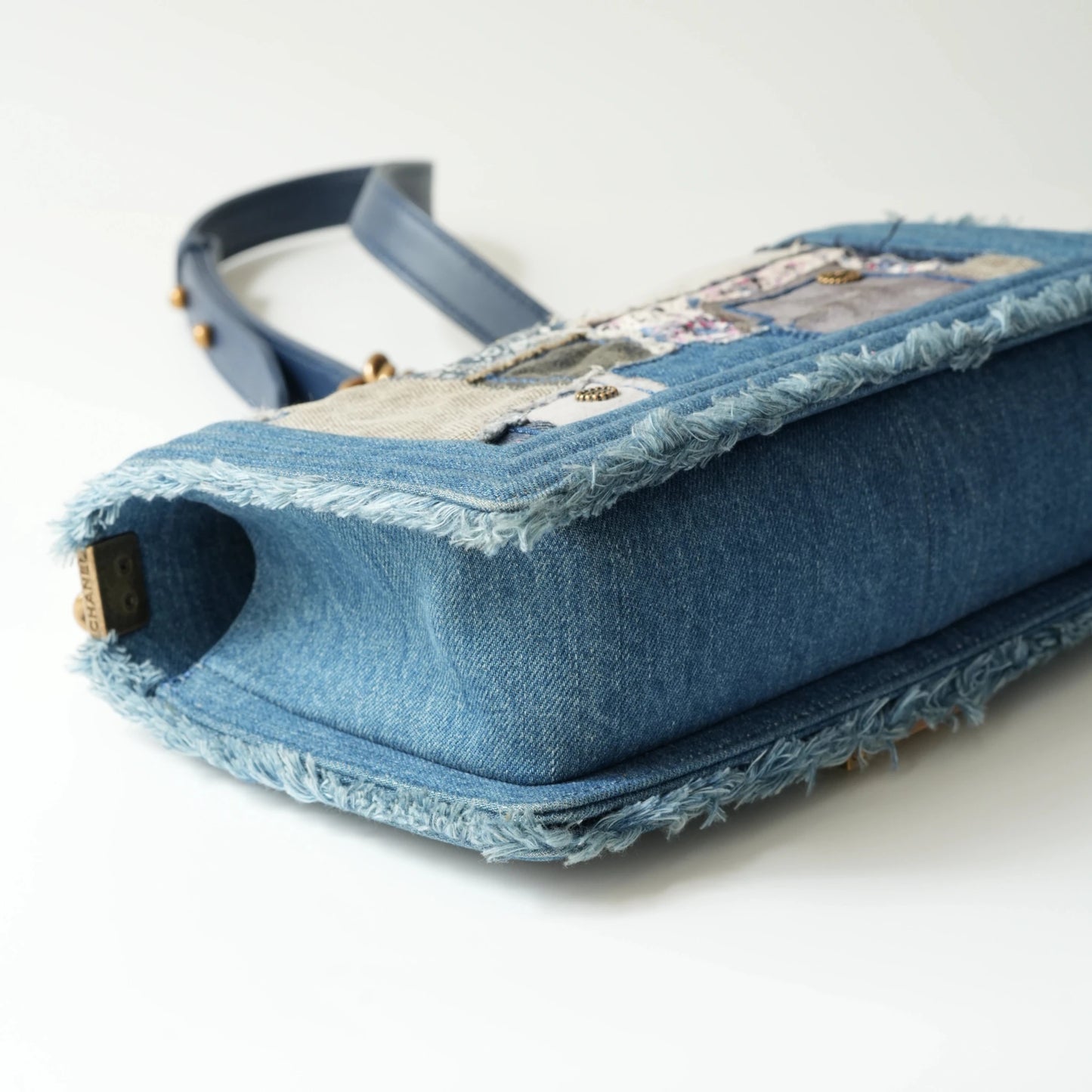Detail view of aged gold Boy clasp and patchwork denim fabric details