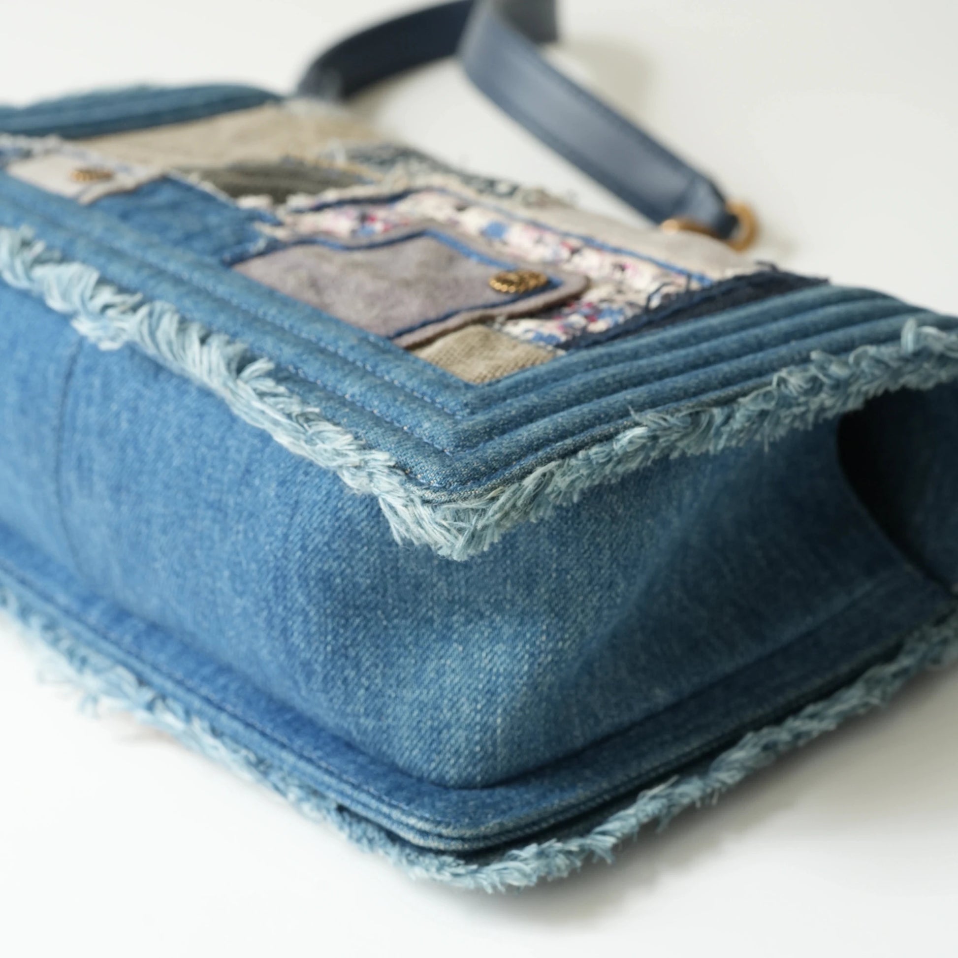 Detail view of aged gold Boy clasp and patchwork denim fabric details