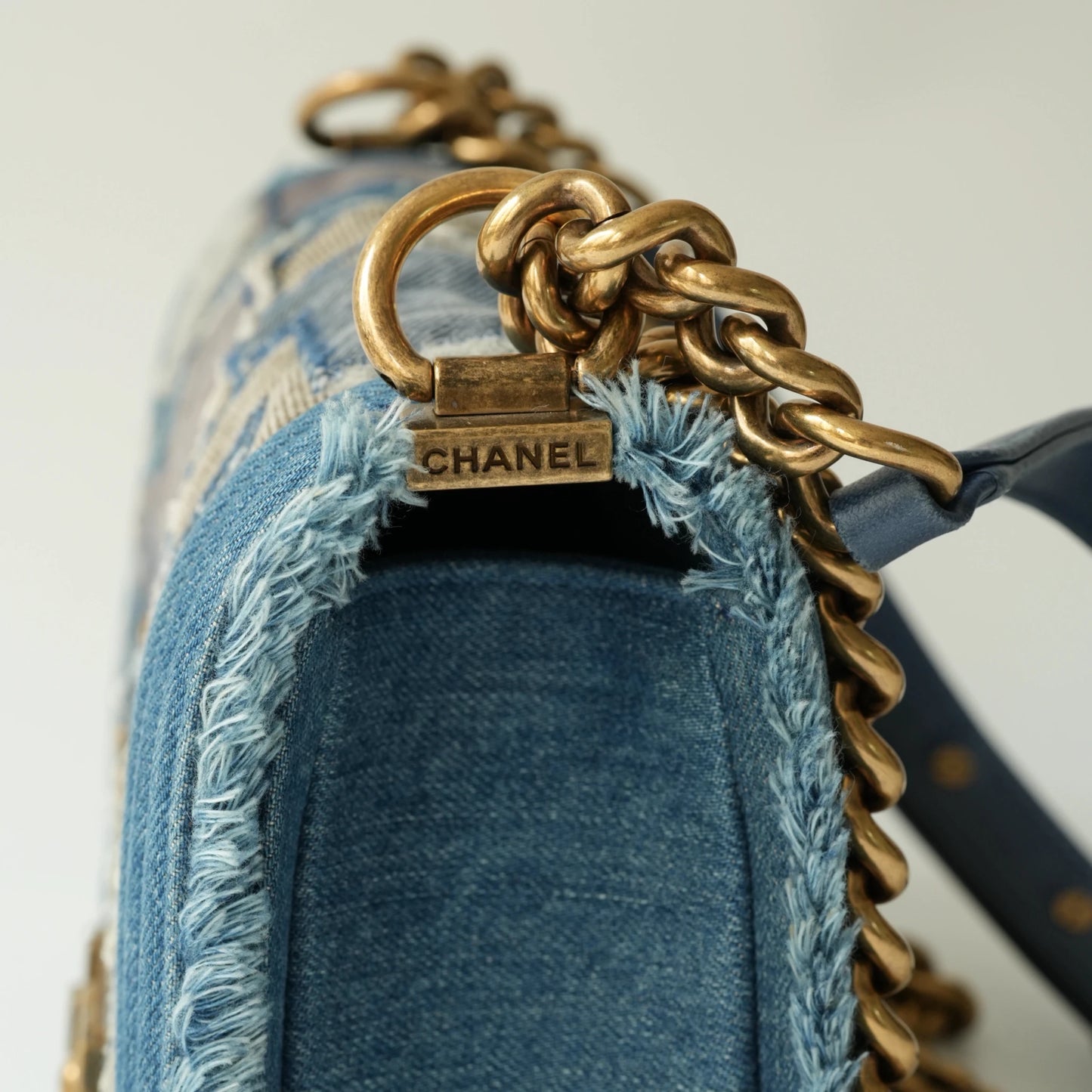 Detail view of aged gold Boy clasp and patchwork denim fabric details