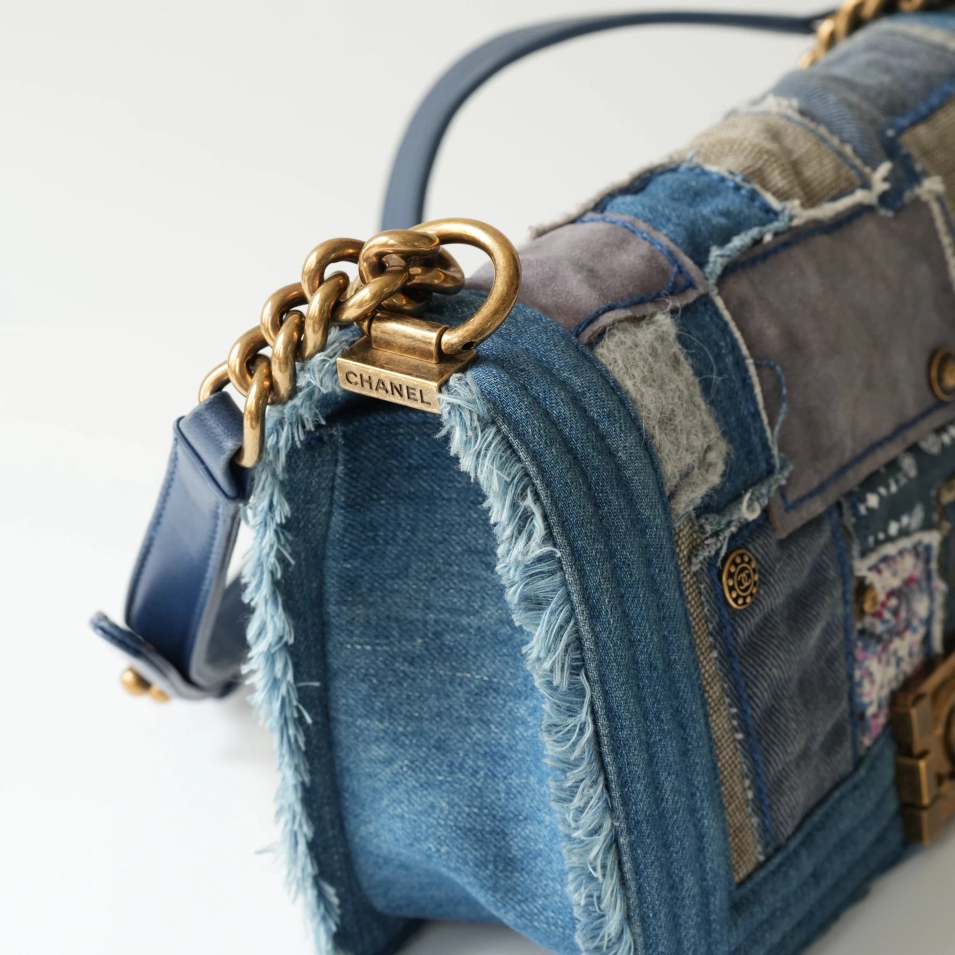 Detail view of aged gold Boy clasp and patchwork denim fabric details