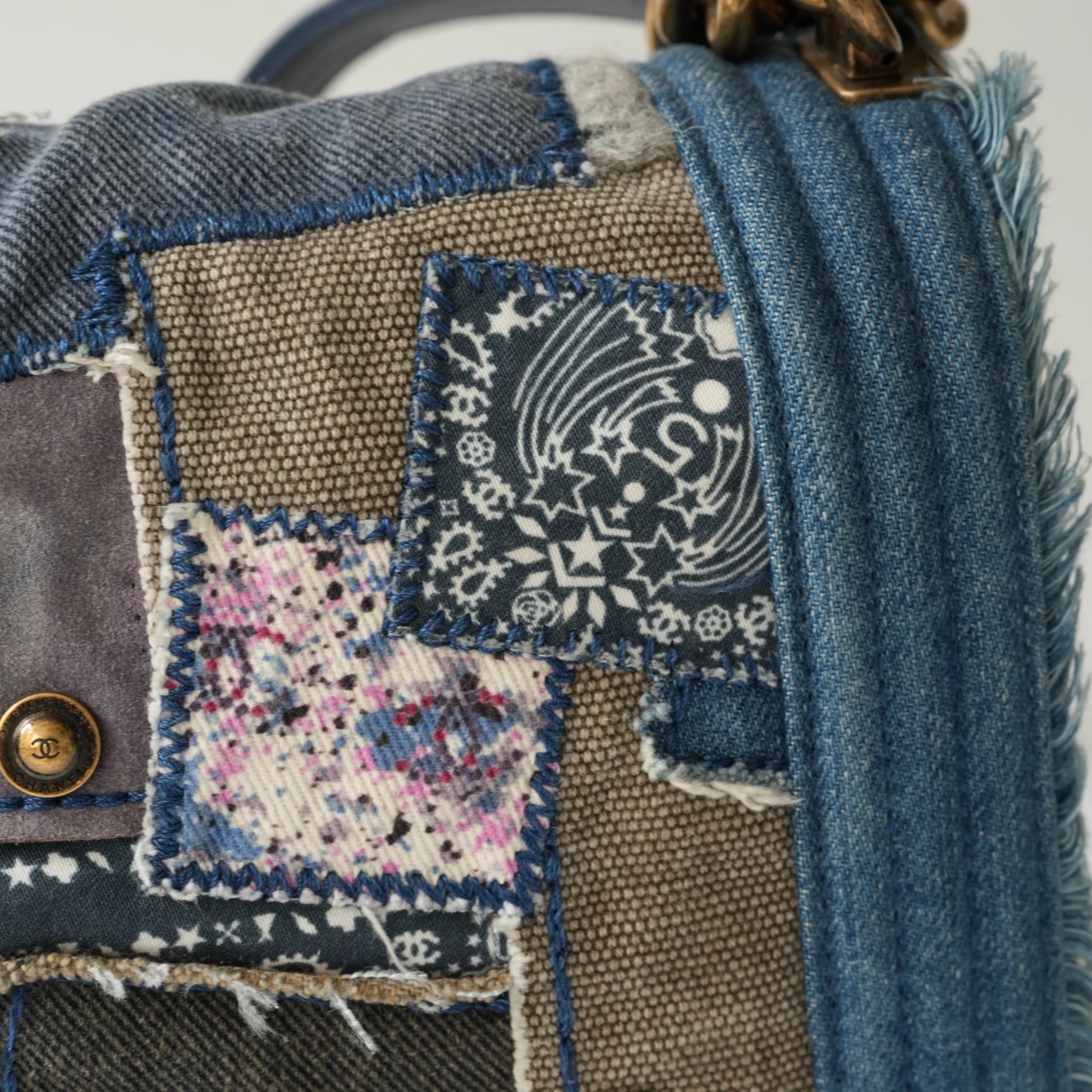 Detail view of aged gold Boy clasp and patchwork denim fabric details