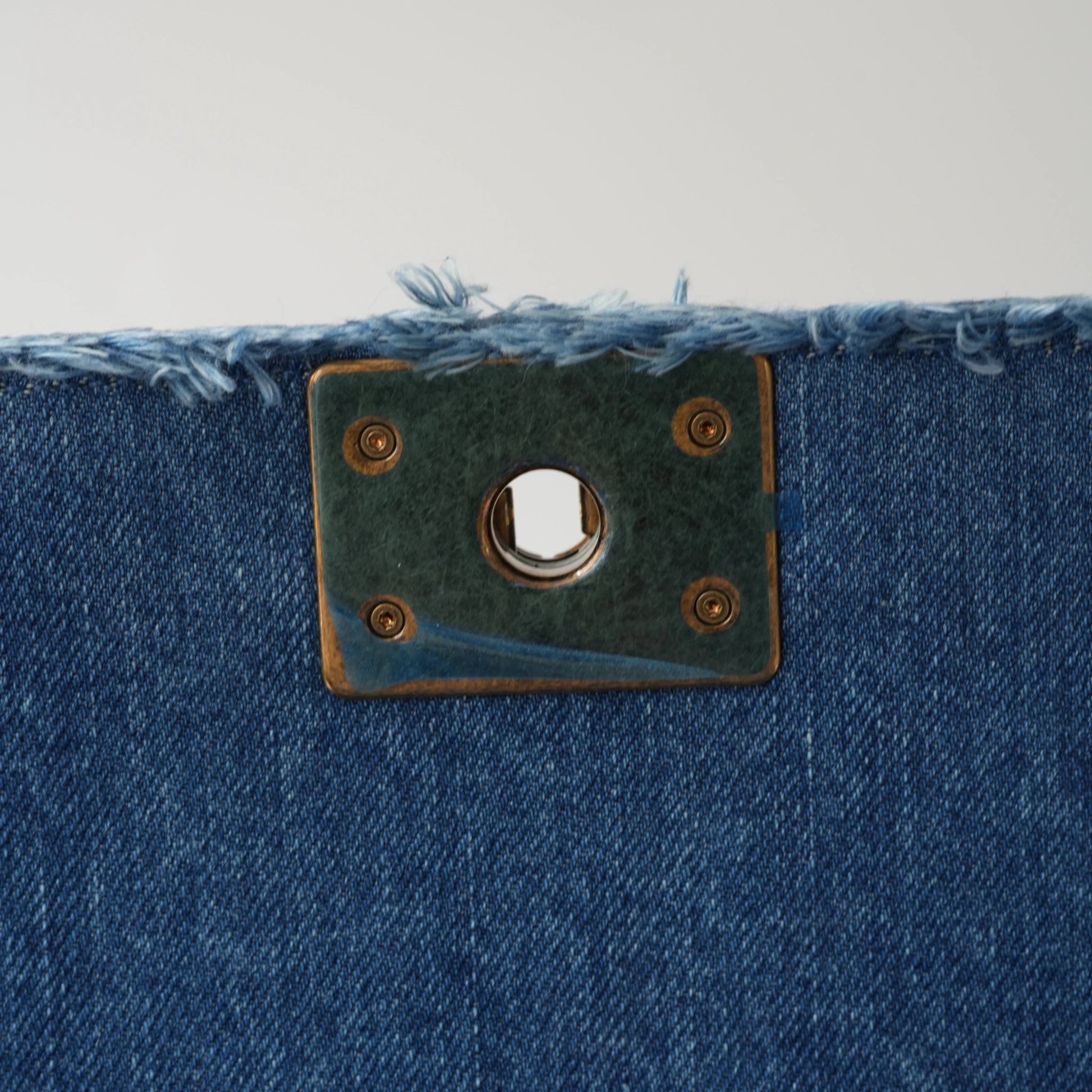 Detail view of aged gold Boy clasp and patchwork denim fabric details