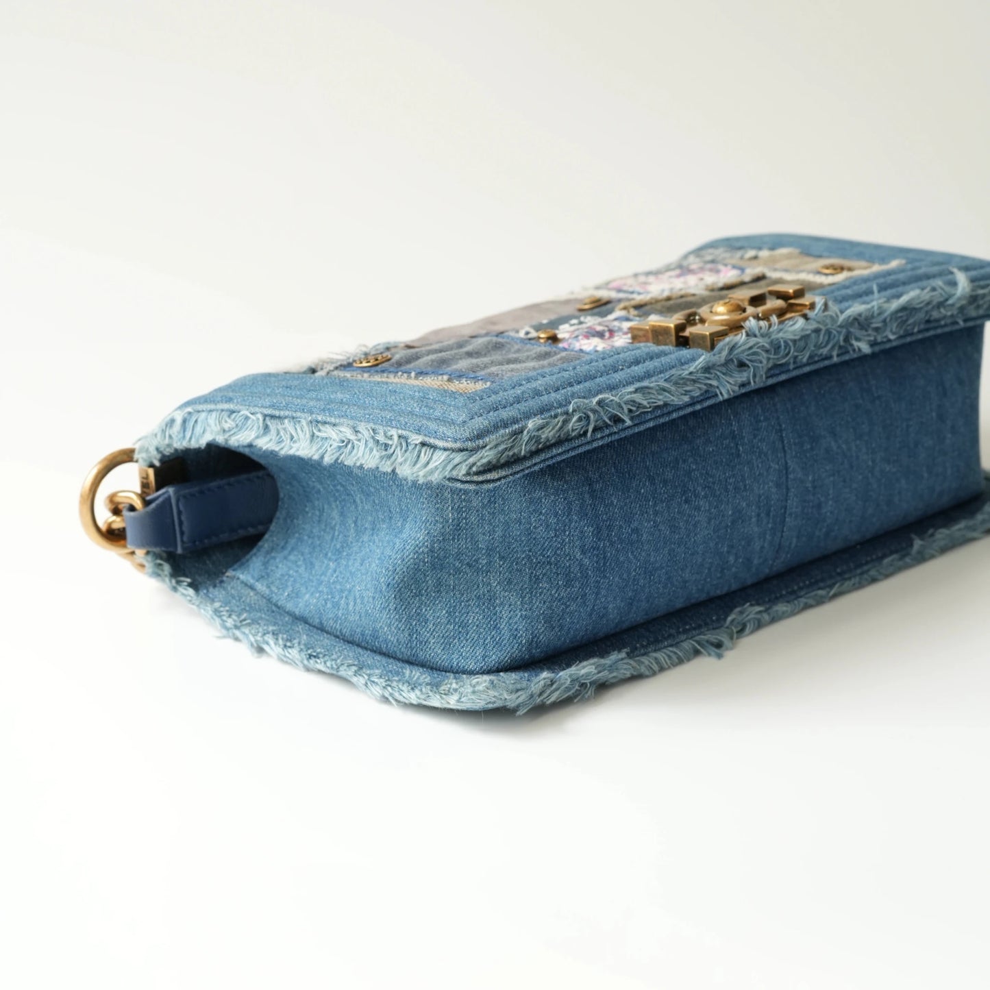 Detail view of aged gold Boy clasp and patchwork denim fabric details