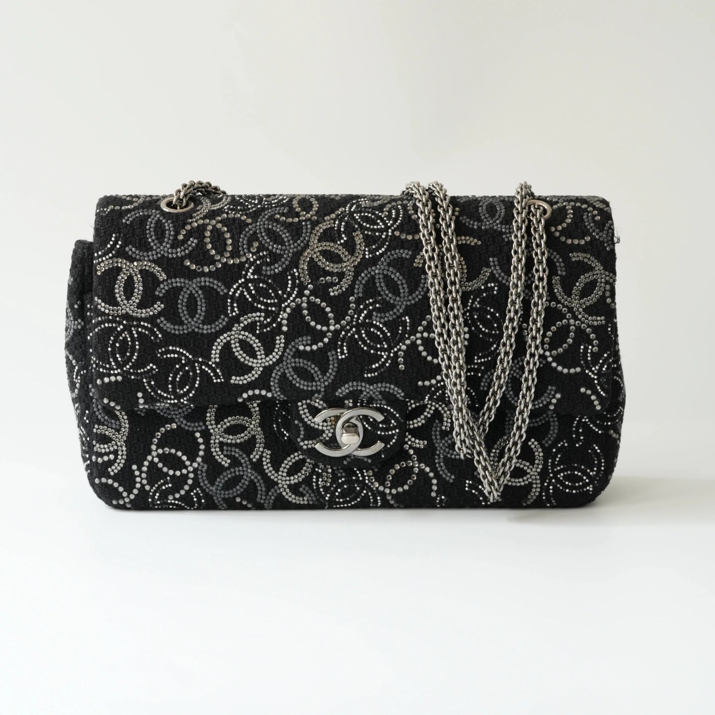 Front view of Chanel classic flap bag with all-over strass crystal CC pattern on black tweed
