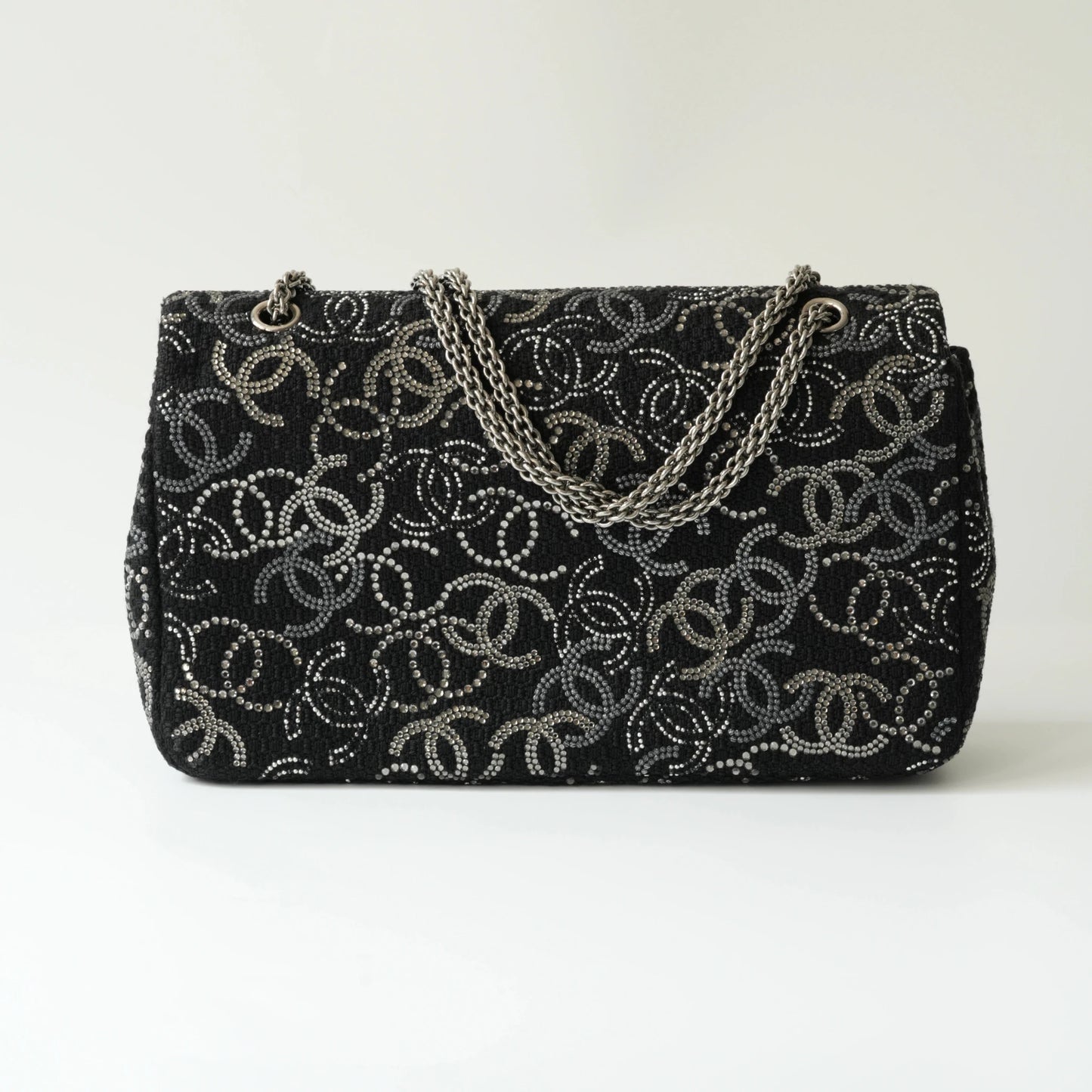 Back view of Chanel classic flap bag in black tweed with crystal CC motif