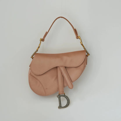 Front view of Dior mini saddle bag in blush pink satin with crystal CD hardware