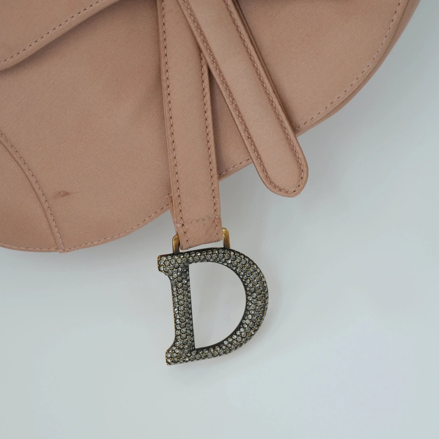Detail view of crystal-embellished D stirrup charm and CD hardware