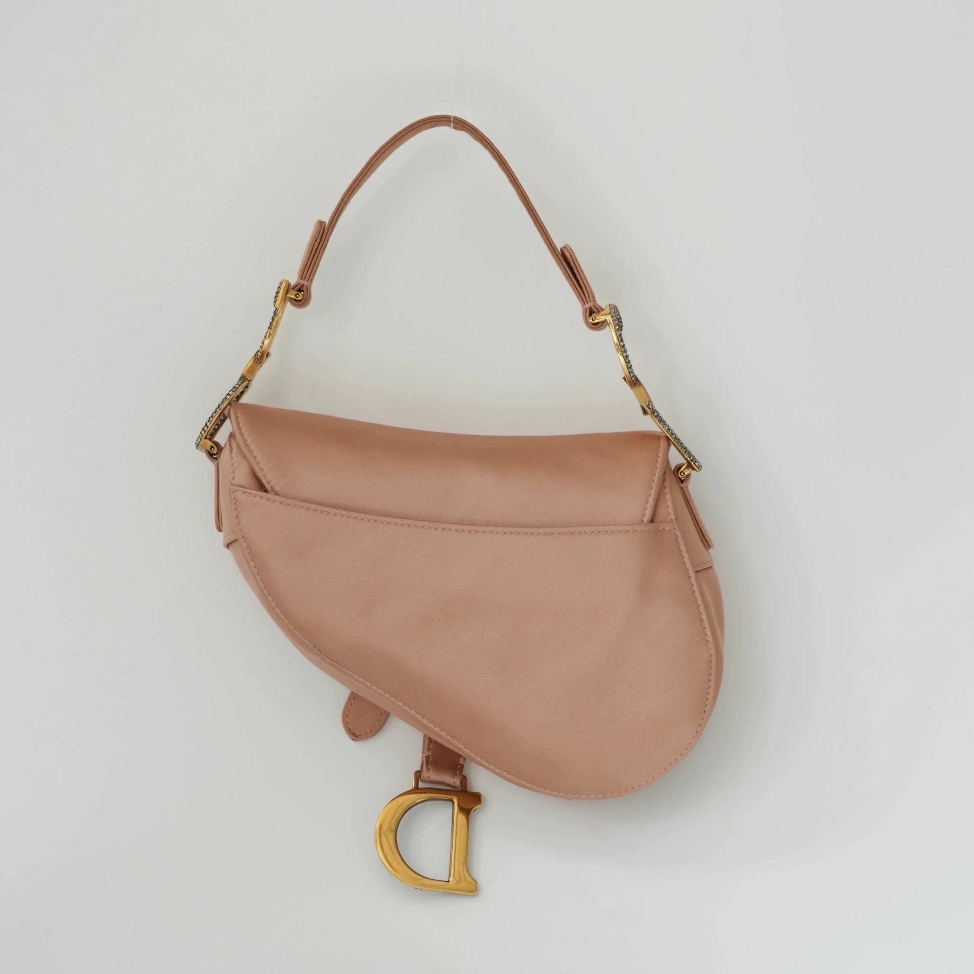 Back view of Dior mini saddle bag in blush pink satin finish