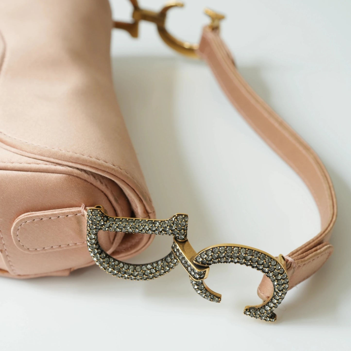 Detail view of crystal-embellished D stirrup charm and CD hardware