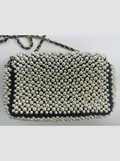 Back view of Chanel pearl embellished mini classic flap bag in black lambskin, neat pearl arrangement and smooth leather rear surface