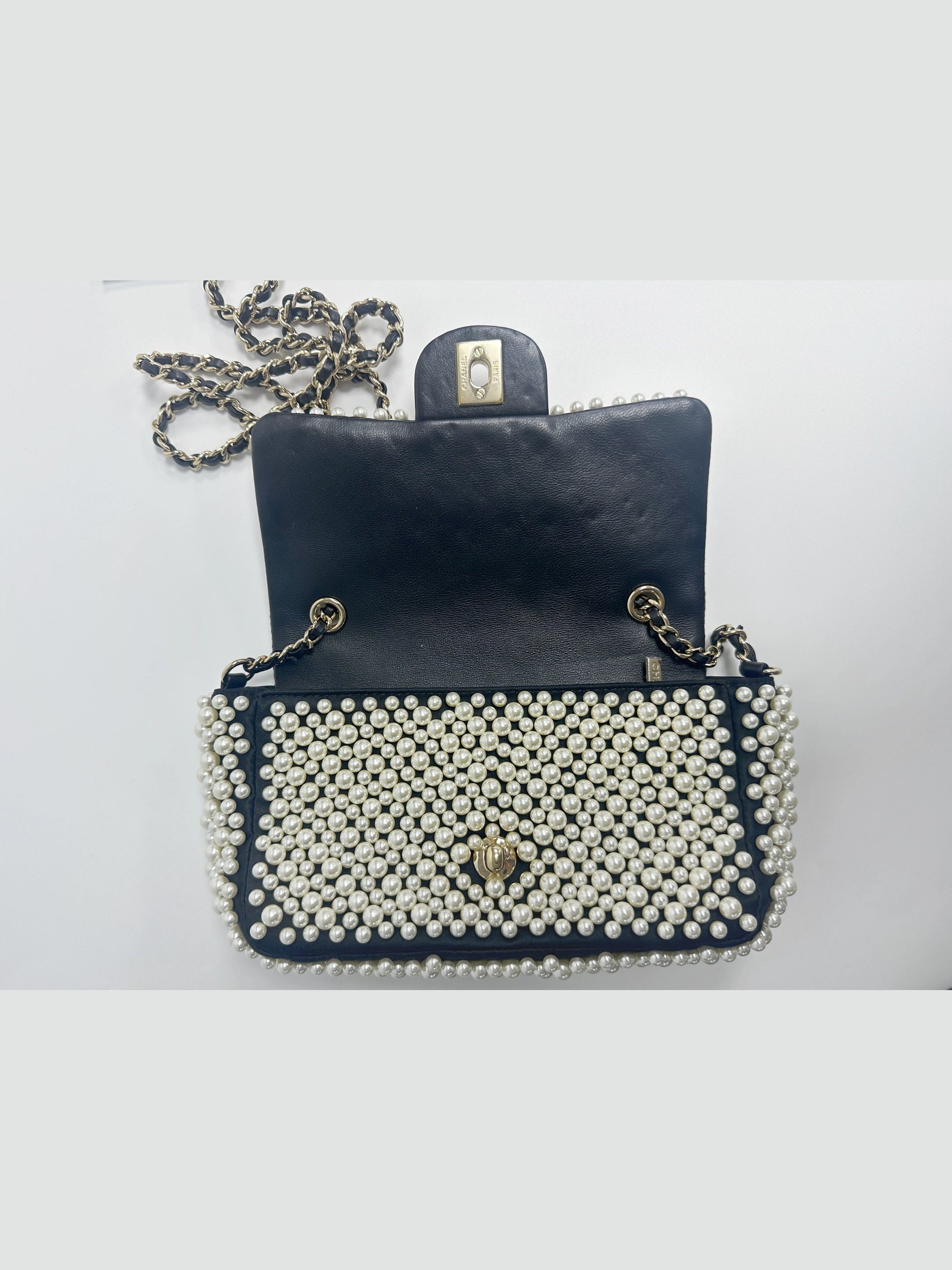 Interior view of Chanel pearl covered mini classic flap handbag, clean inner lambskin compartment with practical storage space
