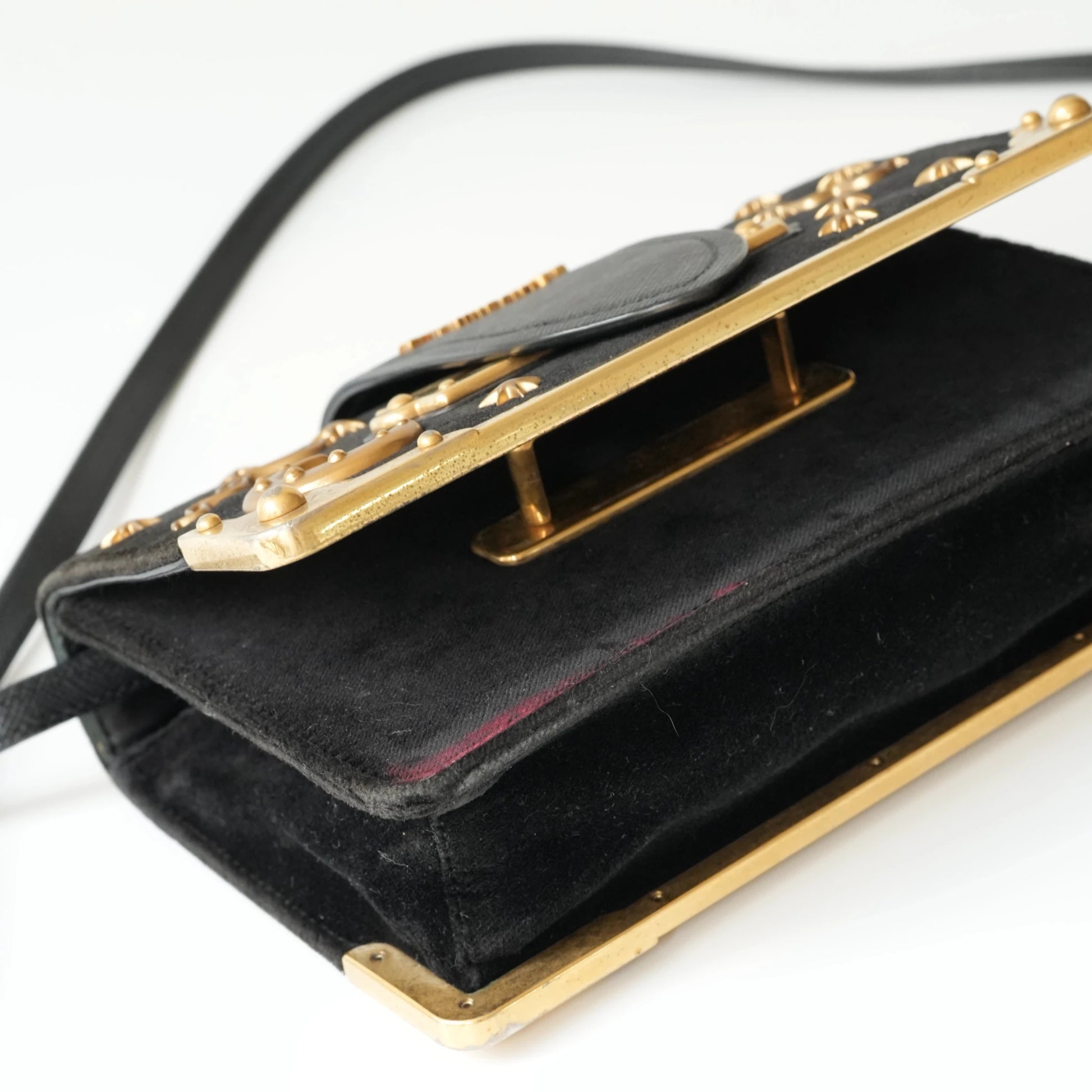 Detail view of gold Prada logo and celestial metal embellishments