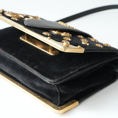 Detail view of gold Prada logo and celestial metal embellishments