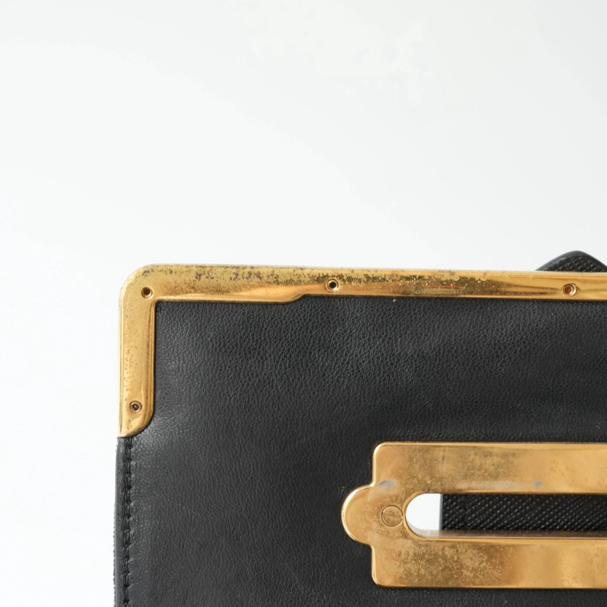 Detail view of gold Prada logo and celestial metal embellishments