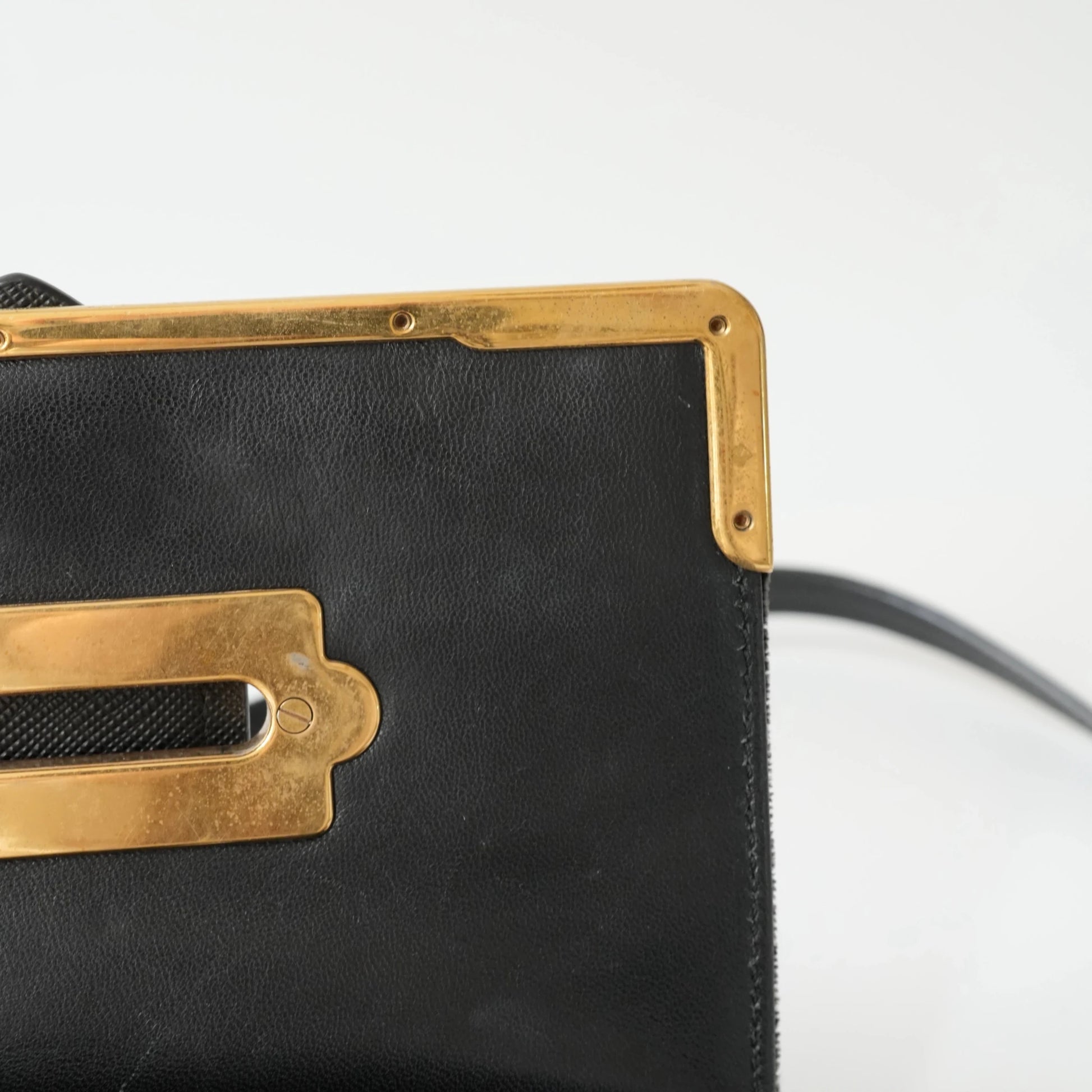 Detail view of gold Prada logo and celestial metal embellishments
