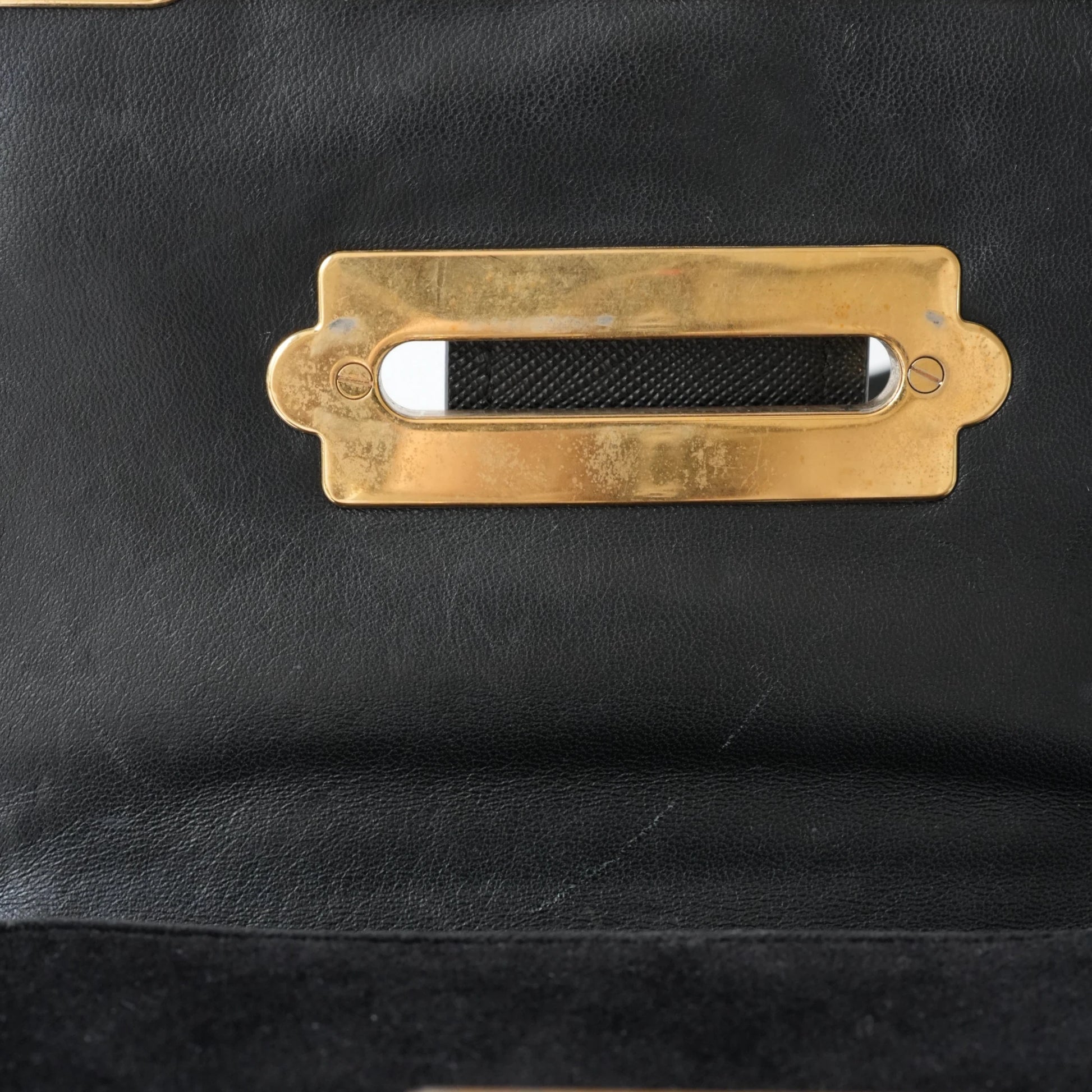 Detail view of gold Prada logo and celestial metal embellishments