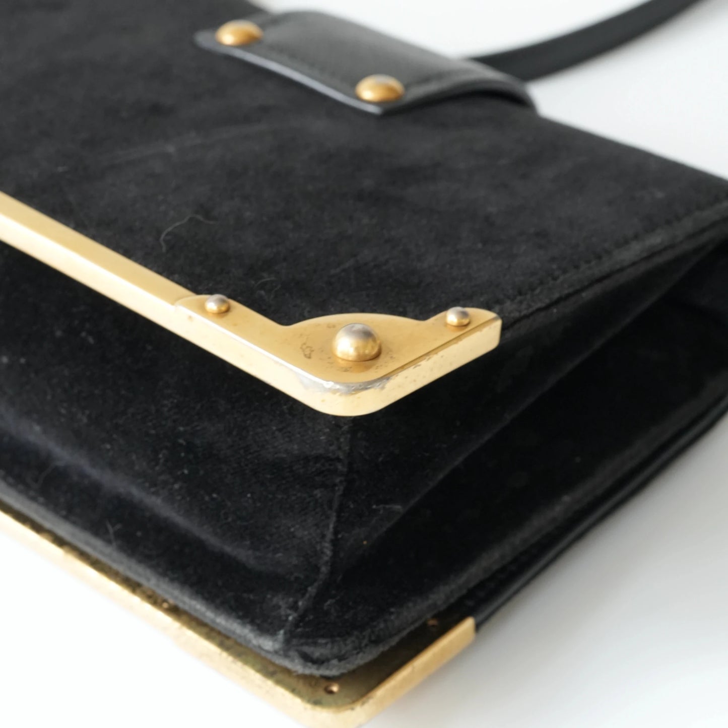 Detail view of gold Prada logo and celestial metal embellishments
