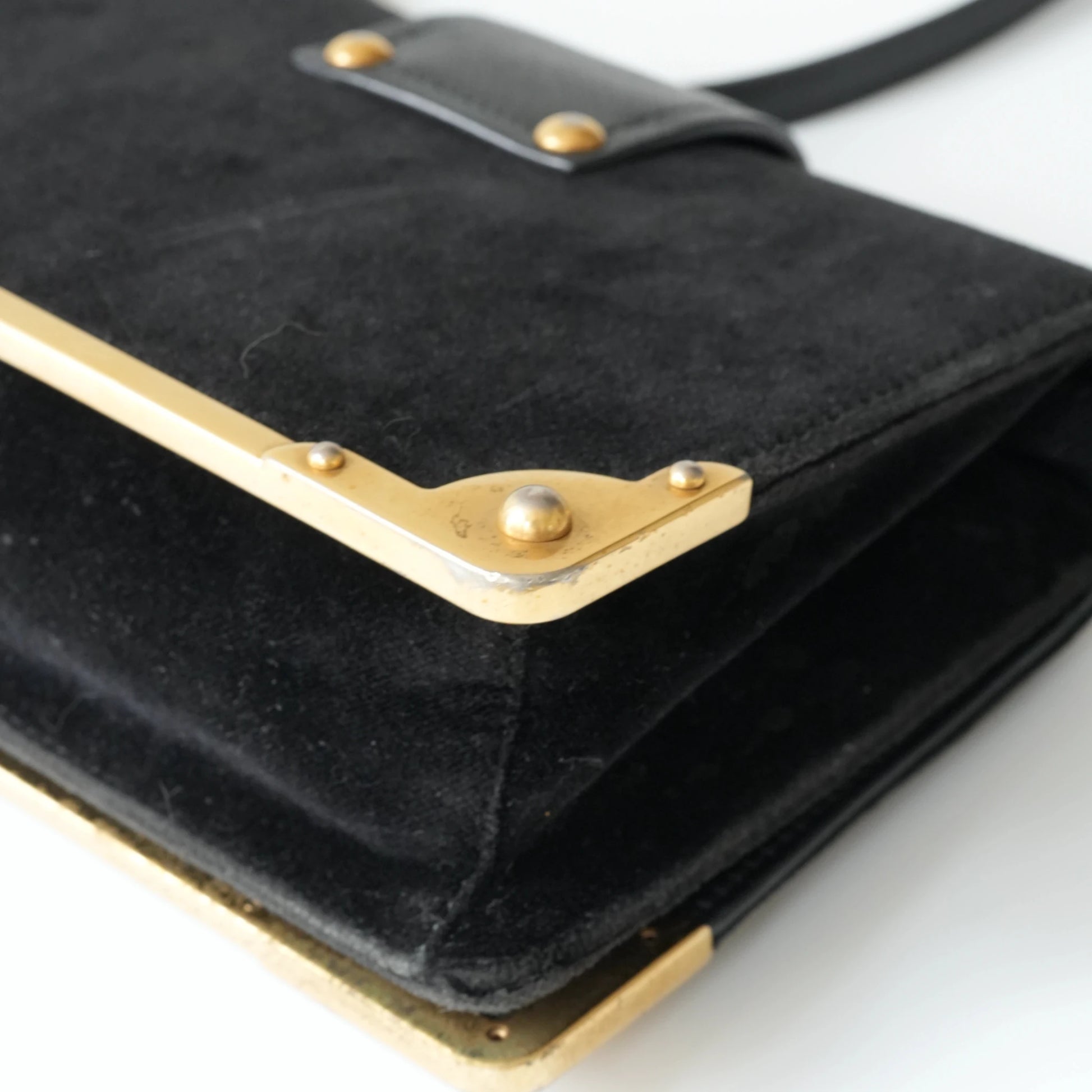Detail view of gold Prada logo and celestial metal embellishments