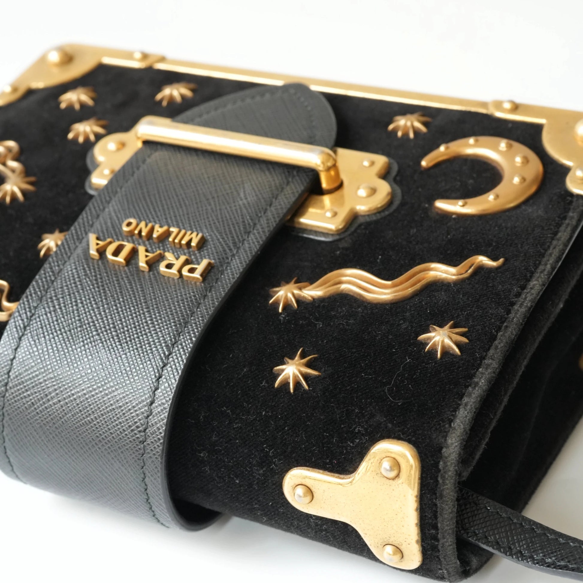 Detail view of gold Prada logo and celestial metal embellishments