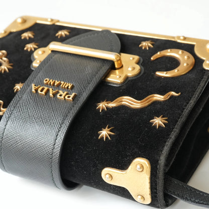 Detail view of gold Prada logo and celestial metal embellishments