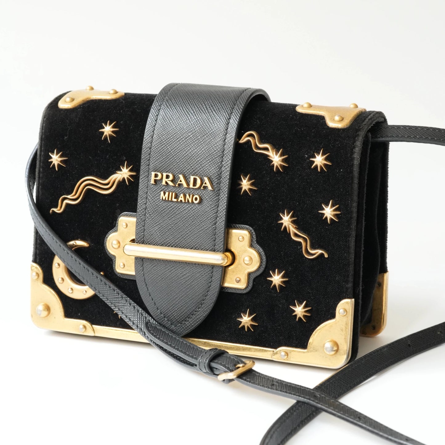 Detail view of gold Prada logo and celestial metal embellishments