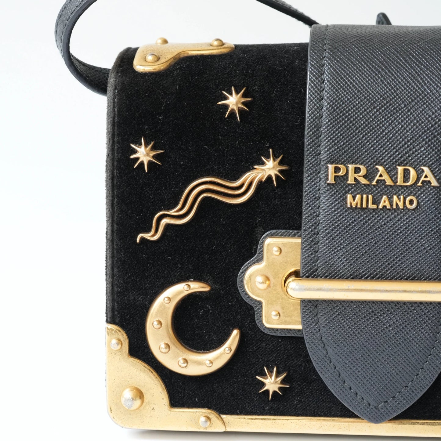 Detail view of gold Prada logo and celestial metal embellishments