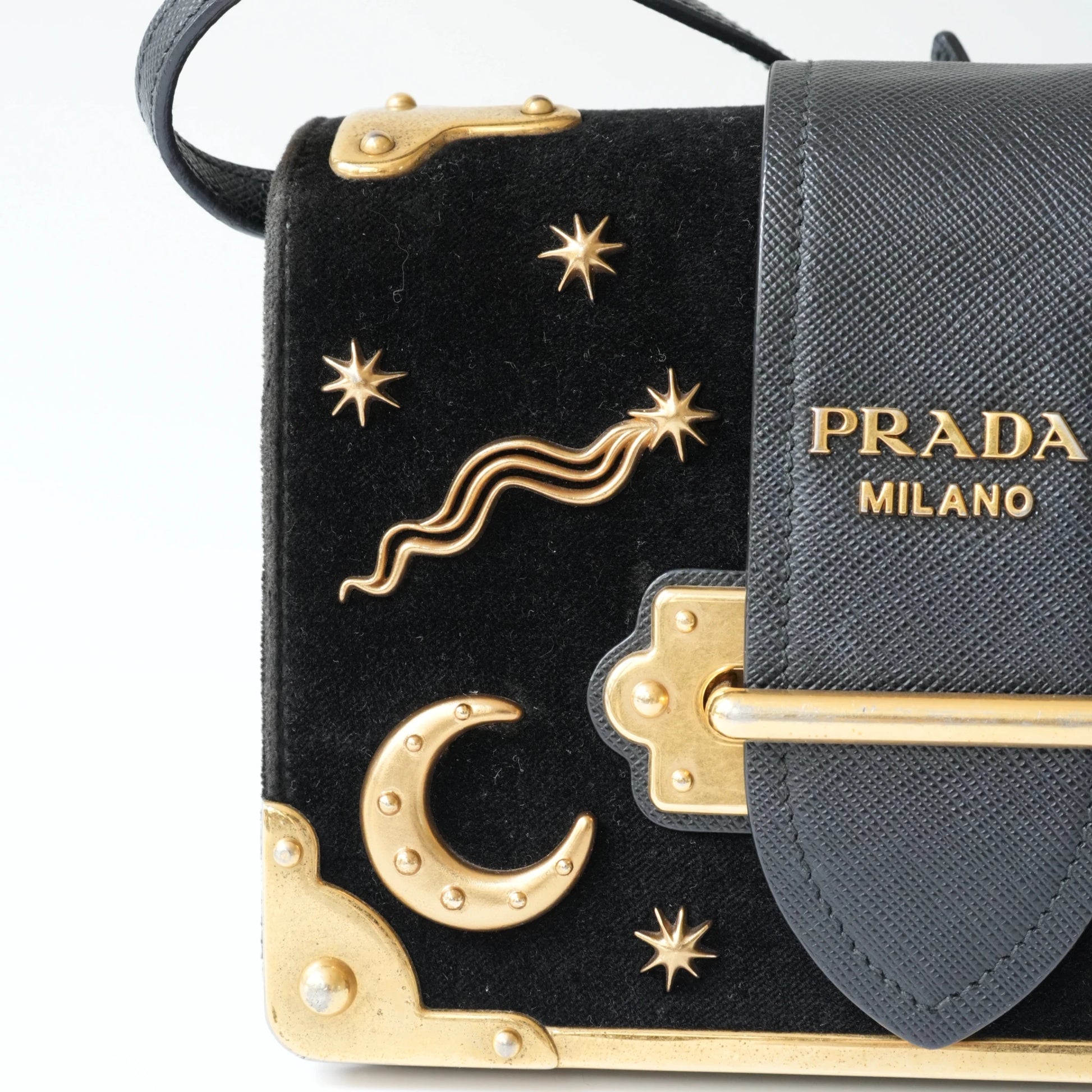 Detail view of gold Prada logo and celestial metal embellishments