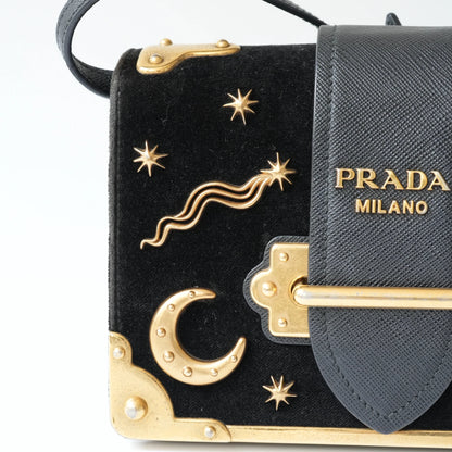 Detail view of gold Prada logo and celestial metal embellishments