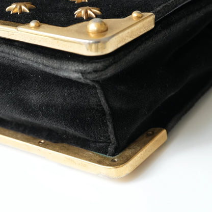 Detail view of gold Prada logo and celestial metal embellishments
