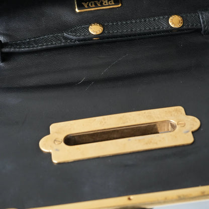 Detail view of gold Prada logo and celestial metal embellishments