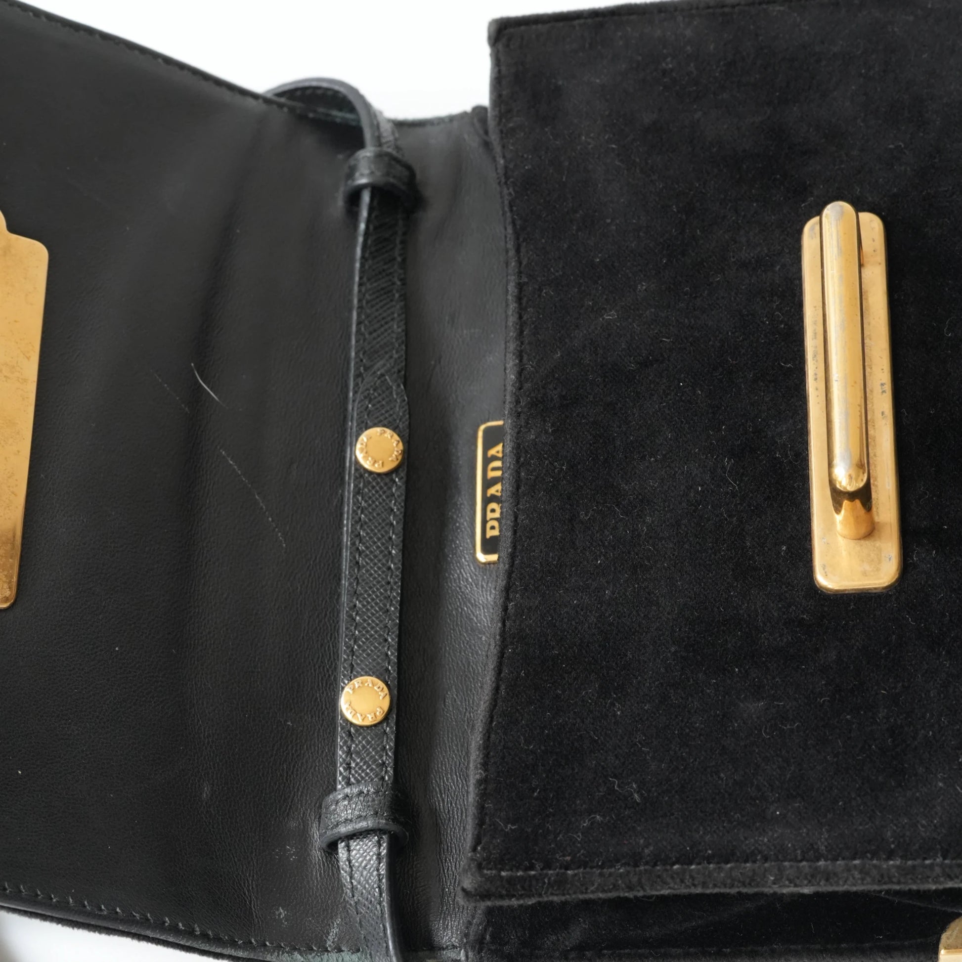 Detail view of gold Prada logo and celestial metal embellishments