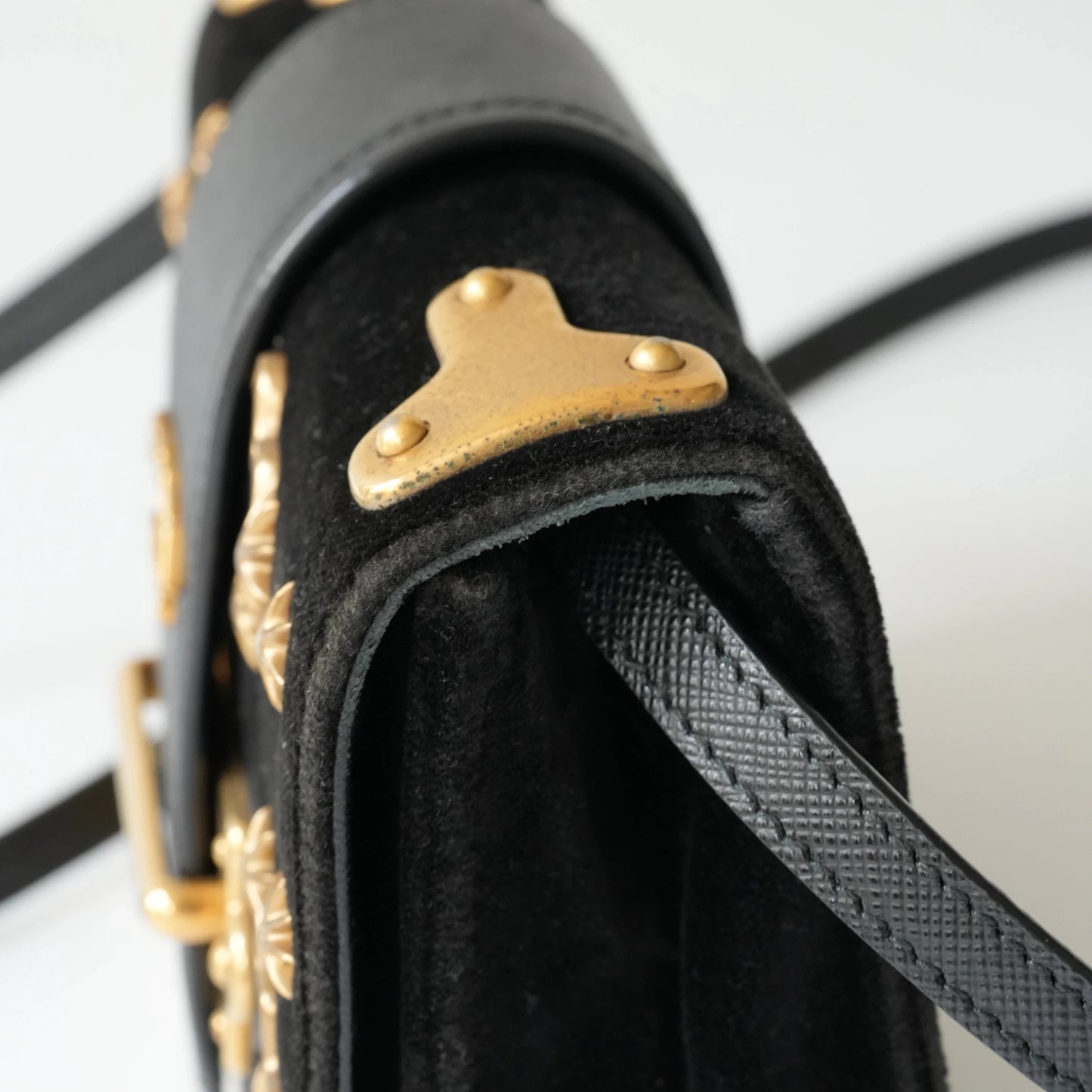 Detail view of gold Prada logo and celestial metal embellishments