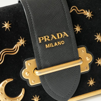 Detail view of gold Prada logo and celestial metal embellishments
